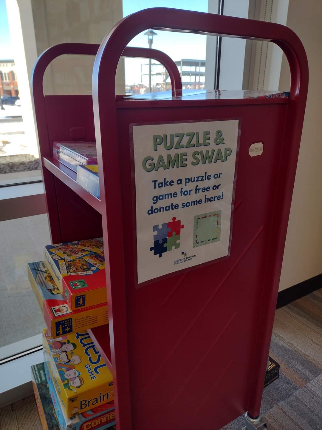 Red cart with puzzles and games with sign that reads Puzzle and Game Swap