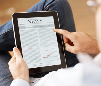 Image of man looking at tablet with word news showing at top