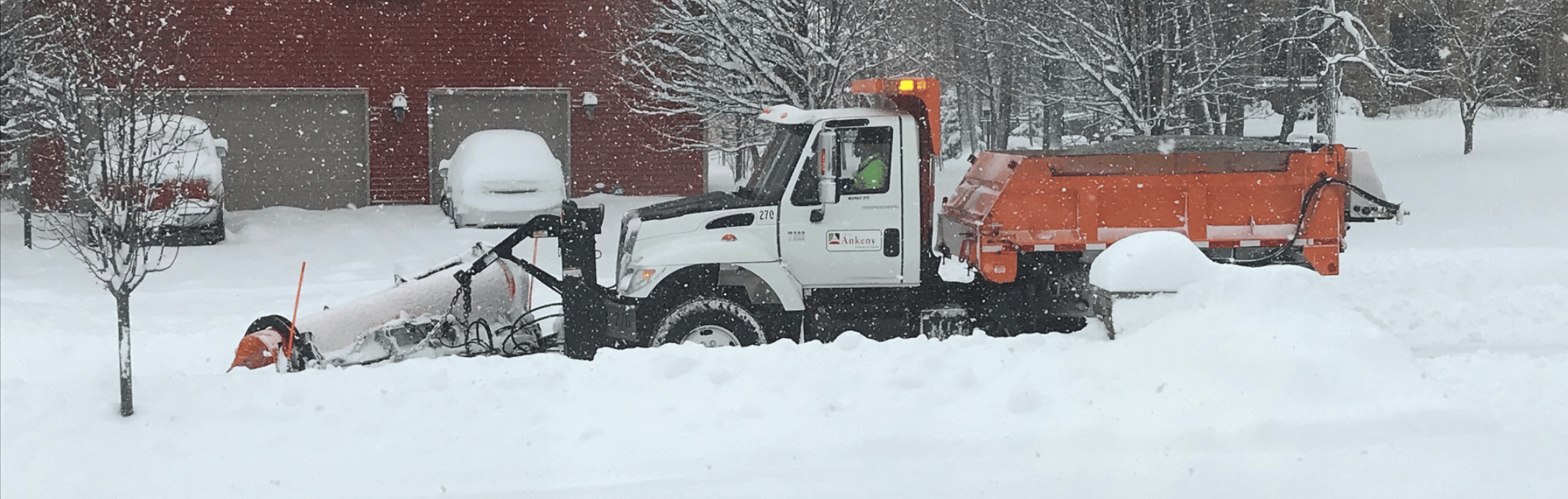 snow plow on a snowy street 