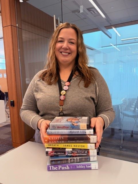 Photo of librarian with stack of 10 items